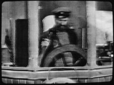 Still Image *Cap'n Tugg at the wheel.* (Donated by Jack Maier)